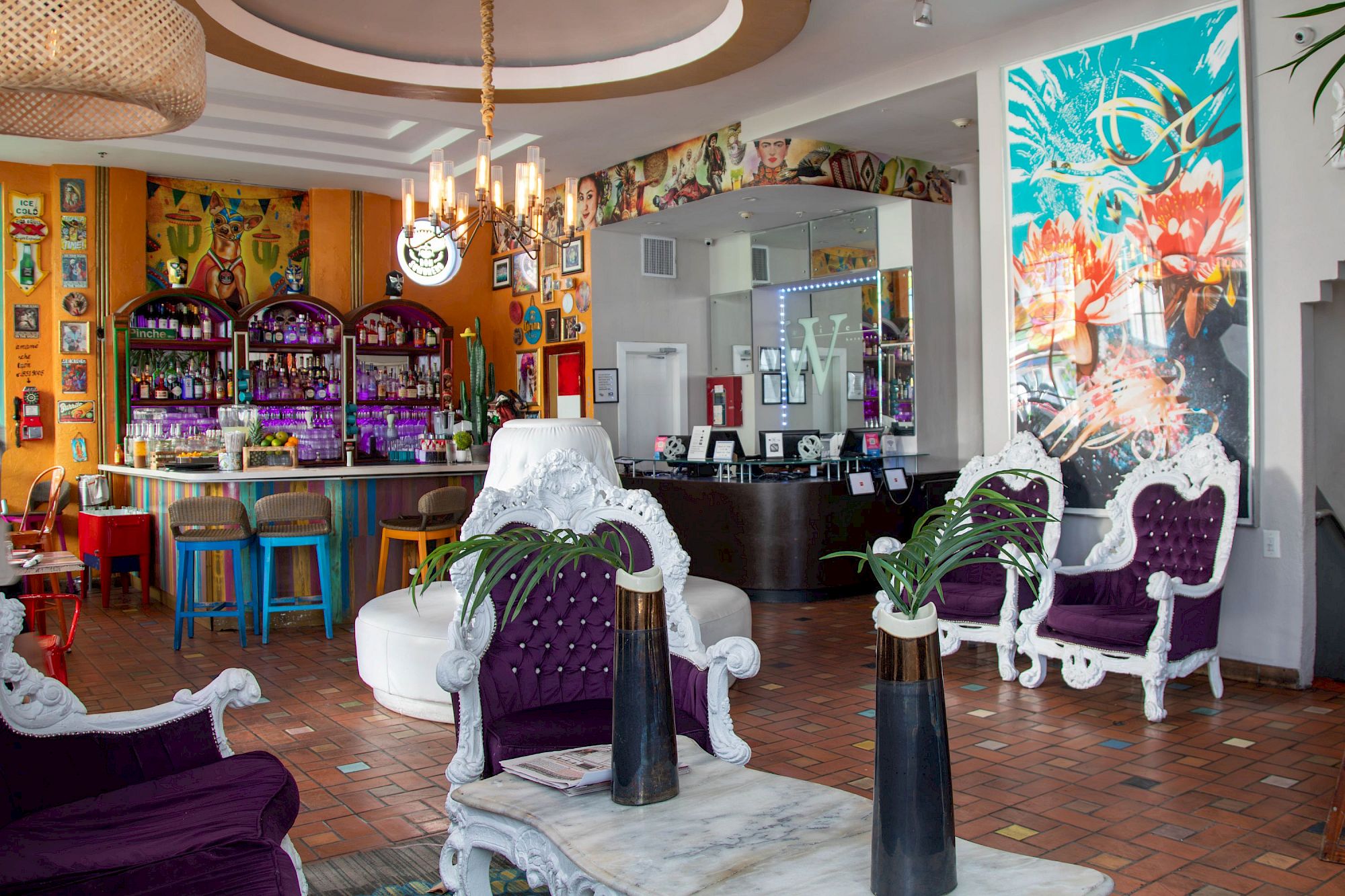 A colorful, retro-style cafe or lounge with vibrant purple chairs, white ornate furniture, tropical wall art, a bar area, and plants, creating a lively, eclectic vibe.