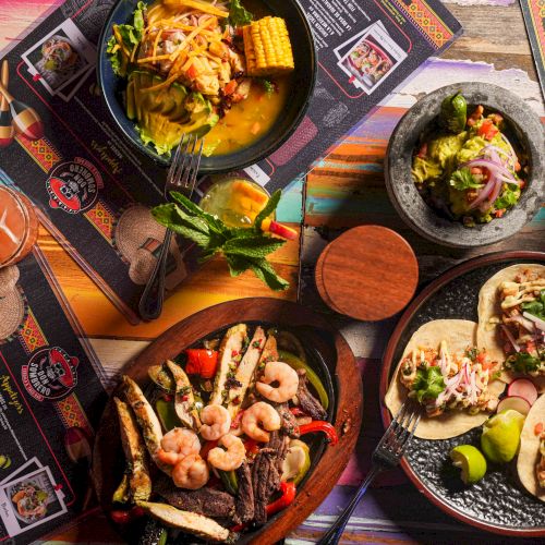 Delicious tapas and tacos spread across colorful plates, featuring shrimp skewers, grilled meats, fresh tortillas, and vibrant garnishes, perfect for sharing.