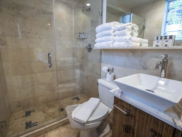 A clean bathroom with a tiled shower, toilet, and sink