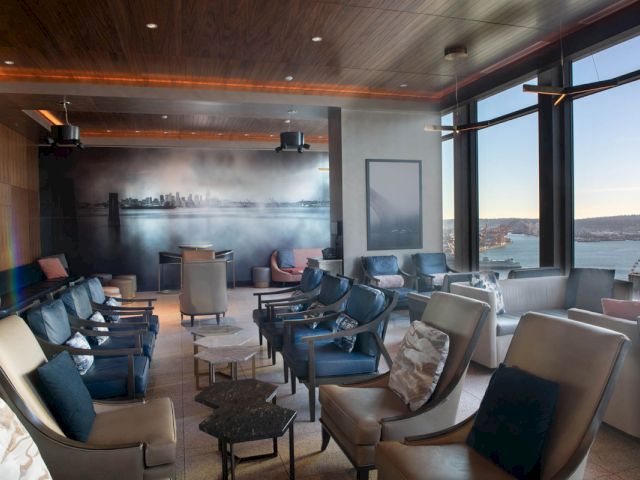 A lounge area with a seating area and large windows showing a view.